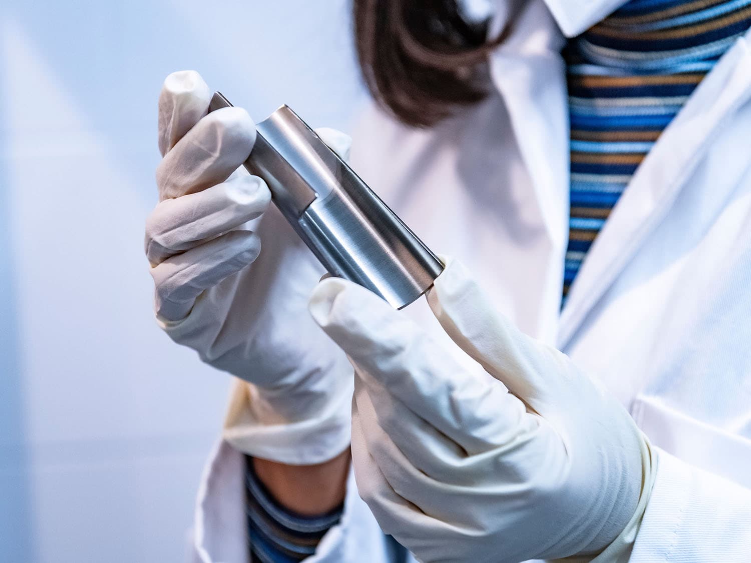 Woman holding a stainless steel half-shell in her hands for inspection