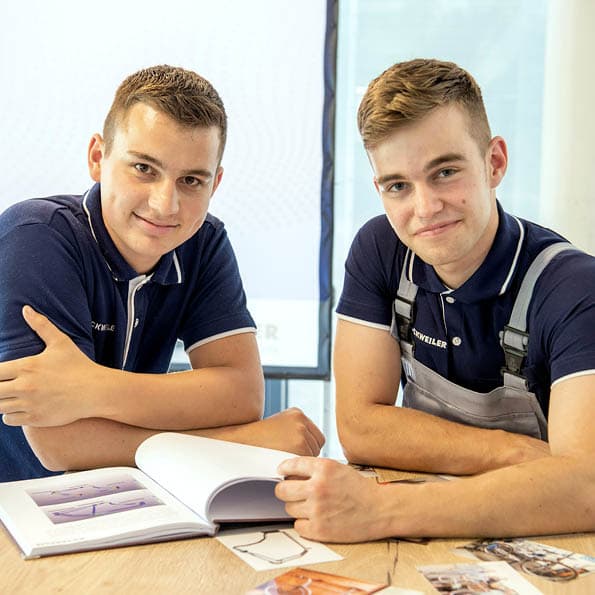 two trainees sitting at a table and looking over a document