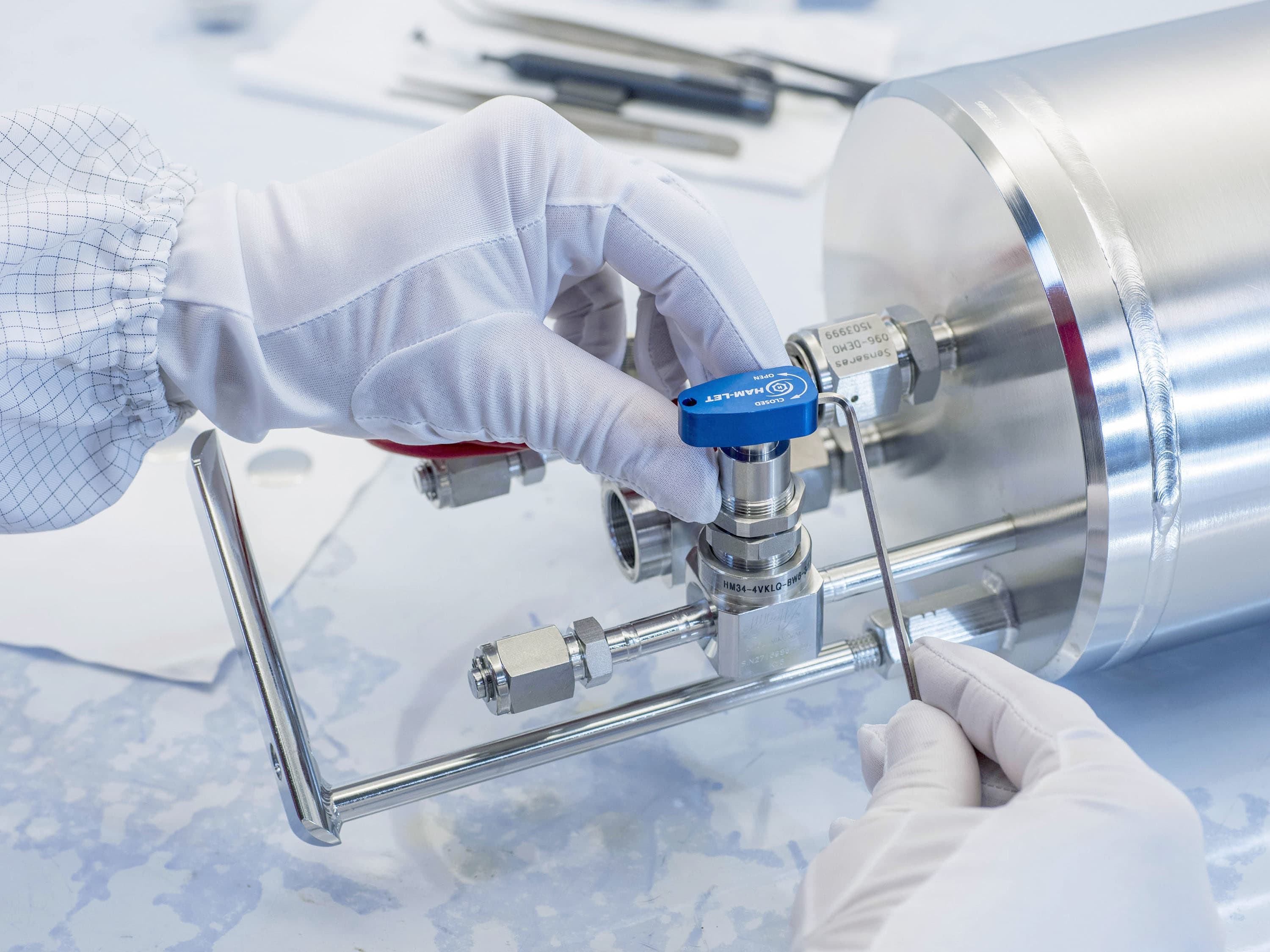 Person wearing white cleanroom gloves doing final assembly work on a process vessel