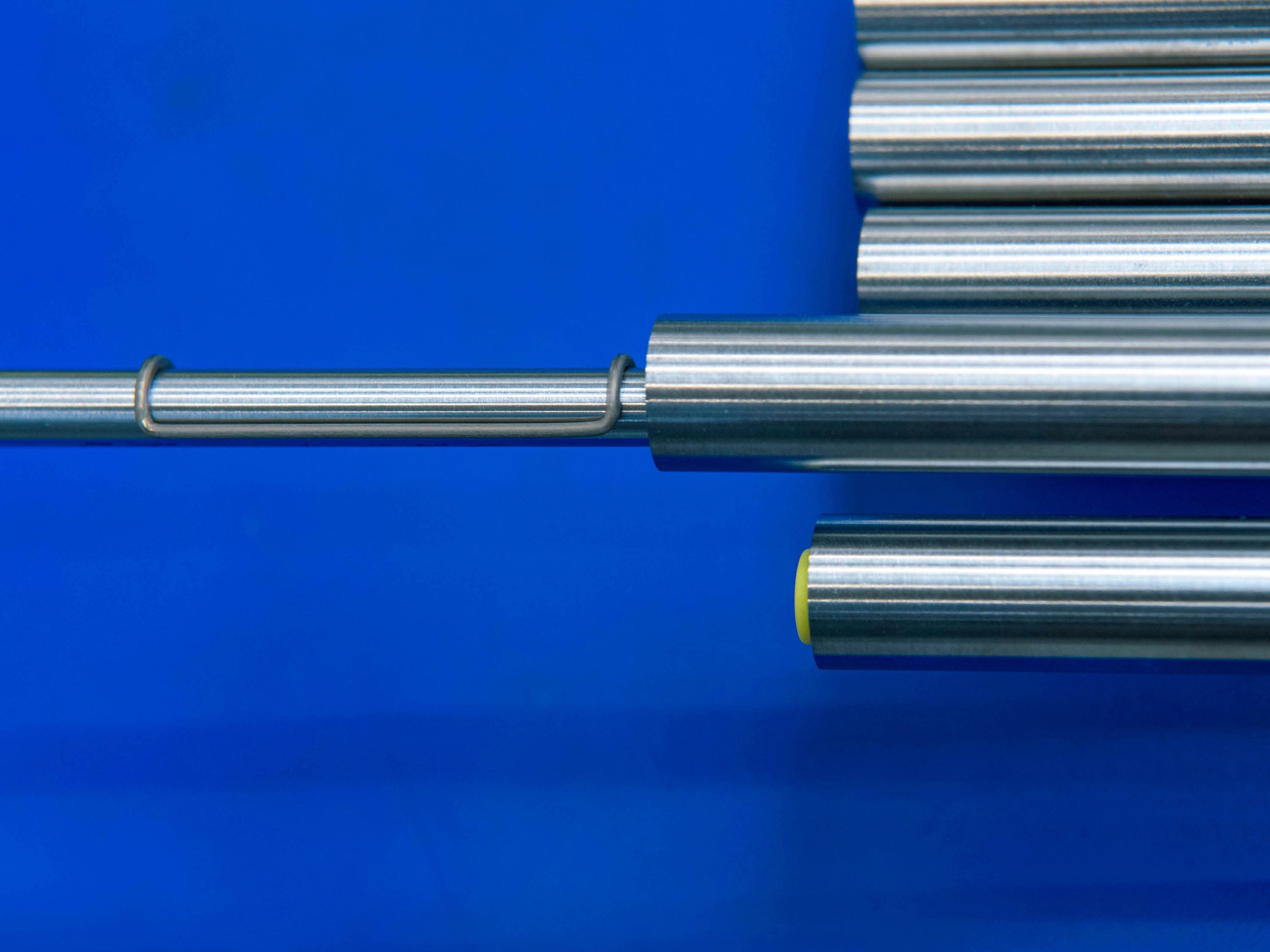 Inner tube with COAX brackets pulled out of outer tube in front of a blue background