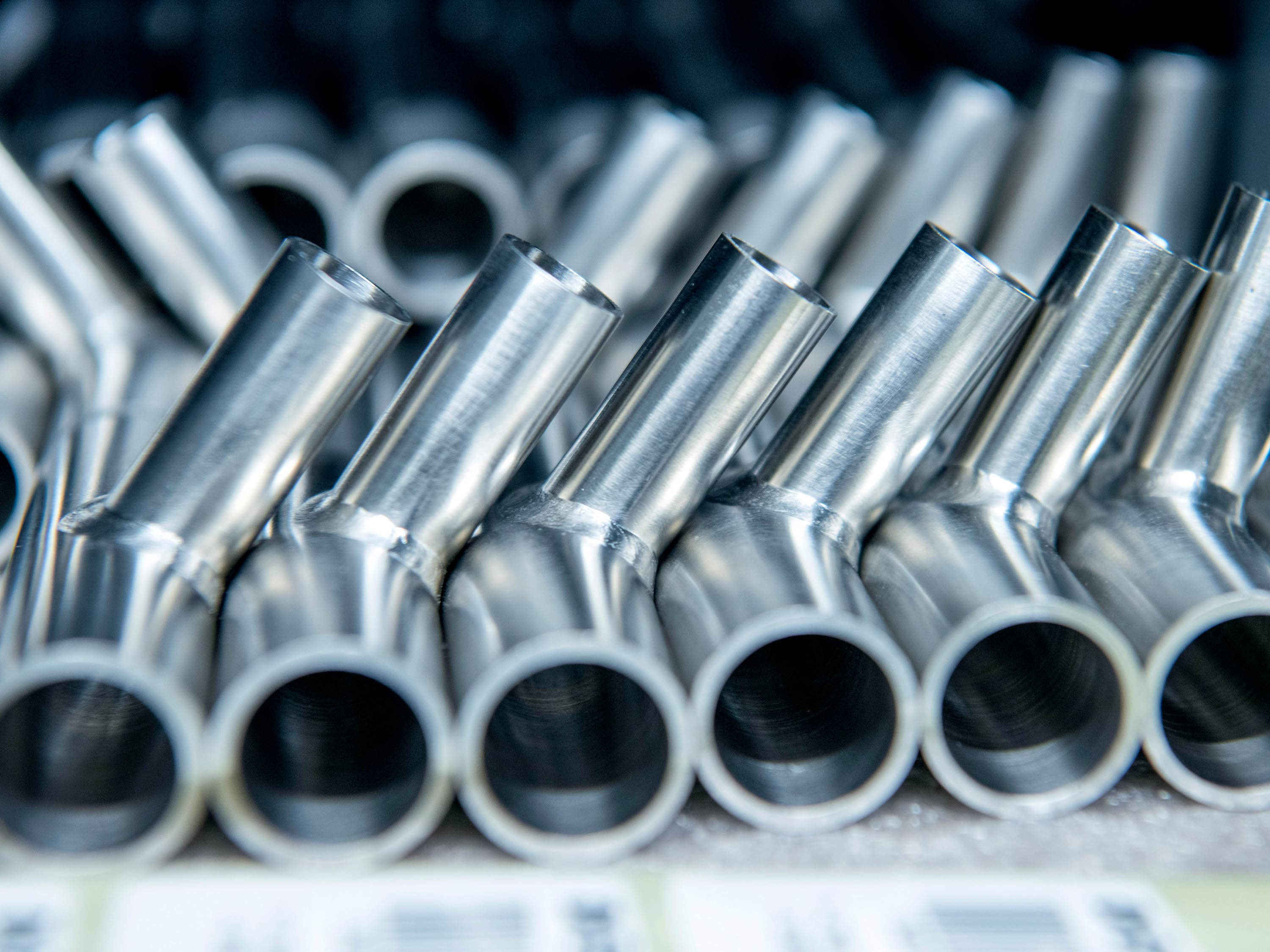 Stainless steel T-pieces are lined up next to each other in the storage compartment