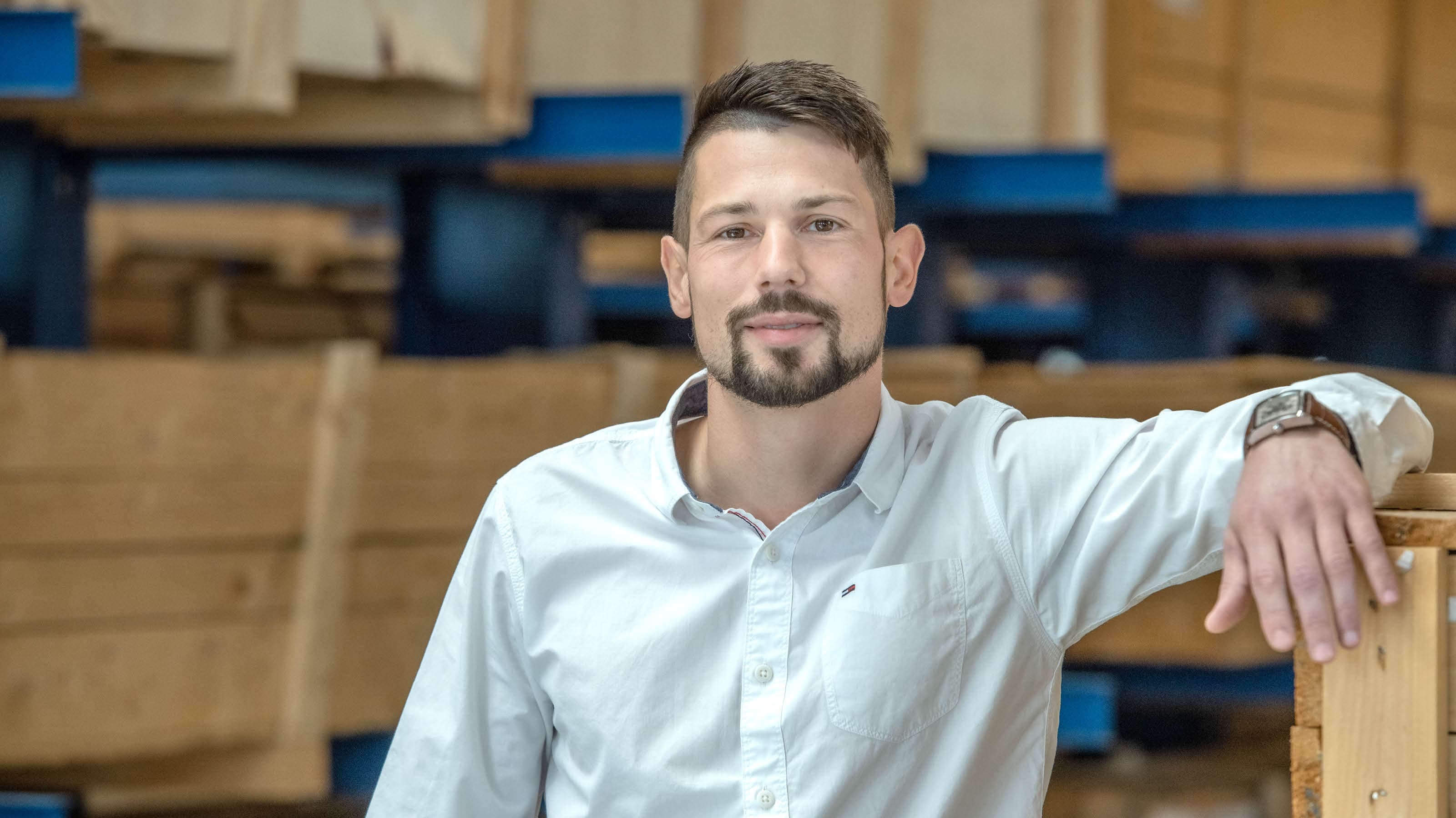 An employee is leaning against a box in the high-bay warehouse
