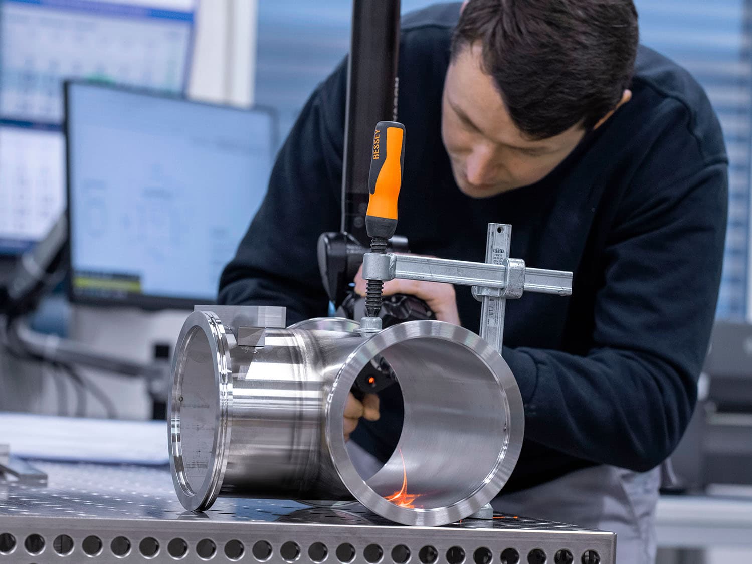 A man is using a 3D measuring method to check a component in production.