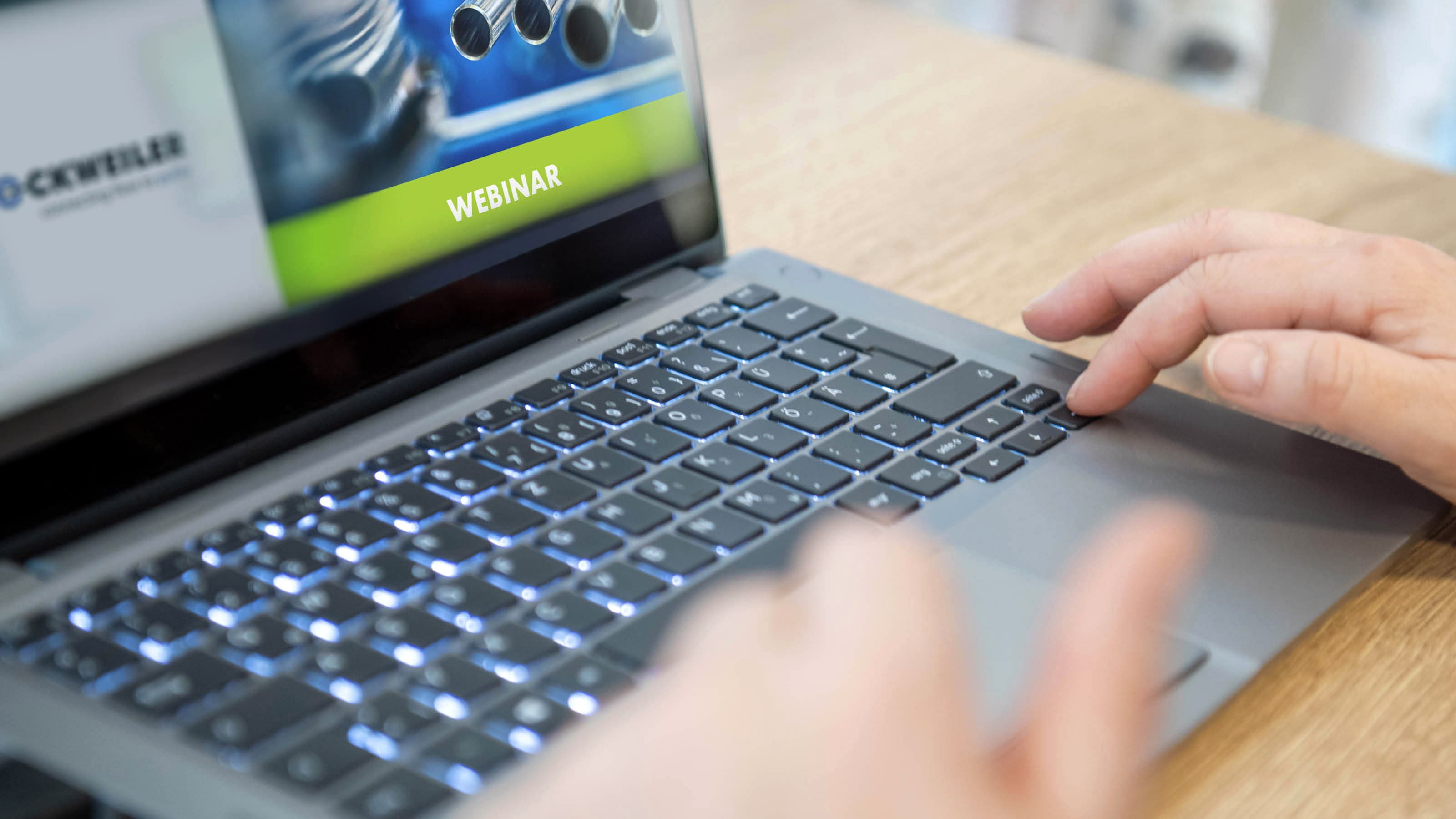 Hands operating a laptop on which a Dockweiler webinar header can be seen